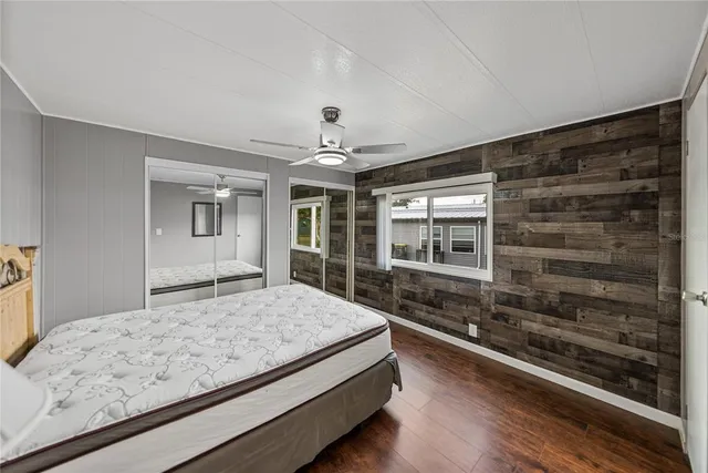 a bedroom with a large bed and a large window with wooden floor