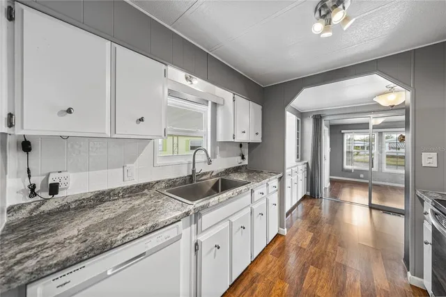 a kitchen with granite countertop a sink and cabinets