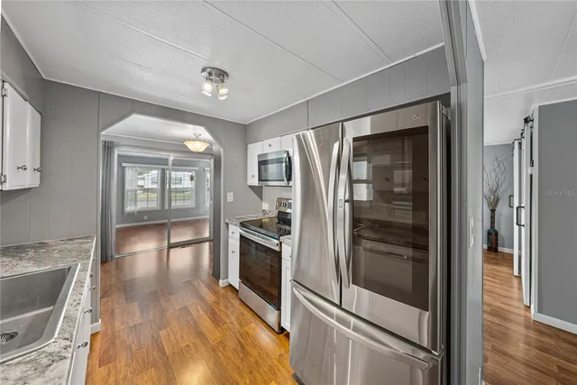 a hallway with wooden floor fireplace and windows
