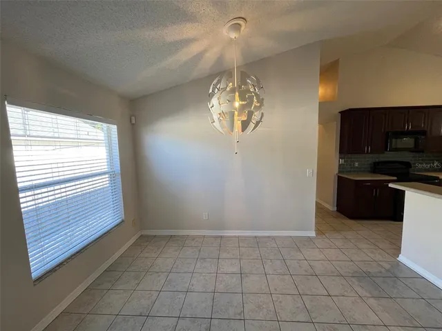 a view of an empty room and kitchen view