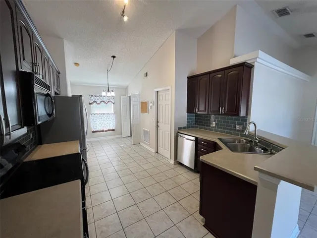 a kitchen with stainless steel appliances a stove refrigerator sink and microwave