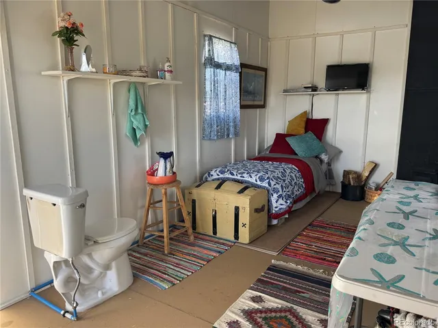 a bedroom with bed and wooden floor