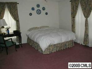 5536 Stack Road Monroe, NC 28112 - Photo 5 of 8 a bed sitting in a bedroom next to a window with chair