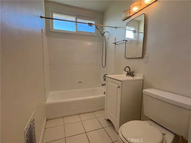 a bathroom with a toilet a sink a mirror and bathtub