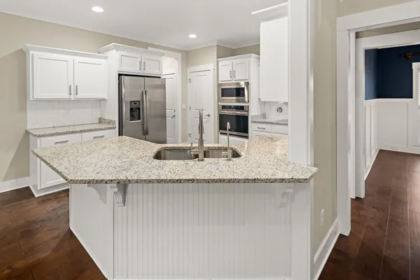 a bathroom with a granite countertop toilet a sink and a mirror