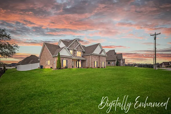 a view of a big house with a big yard and large trees