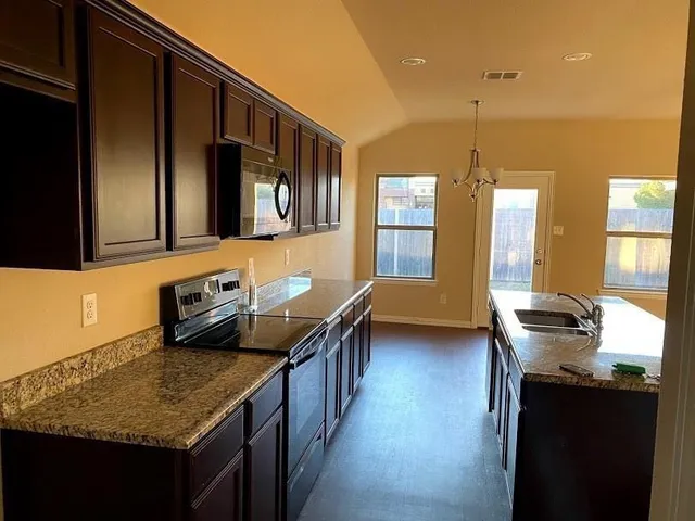 a view of a kitchen with a sink and a large window