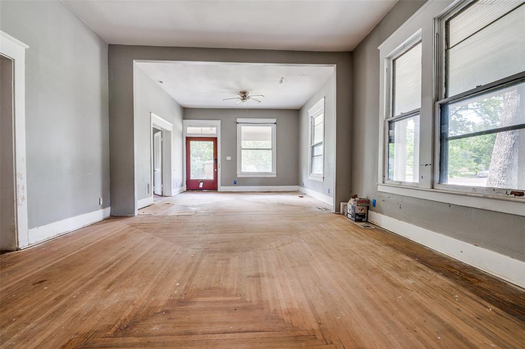 408 West Decatur Street Ennis, TX 75119 - Photo 2 of 15 a view of an empty room with a window and wooden floor
