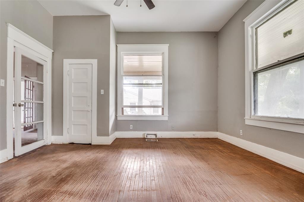408 West Decatur Street Ennis, TX 75119 - Photo 6 of 15 an empty room with wooden floor and windows