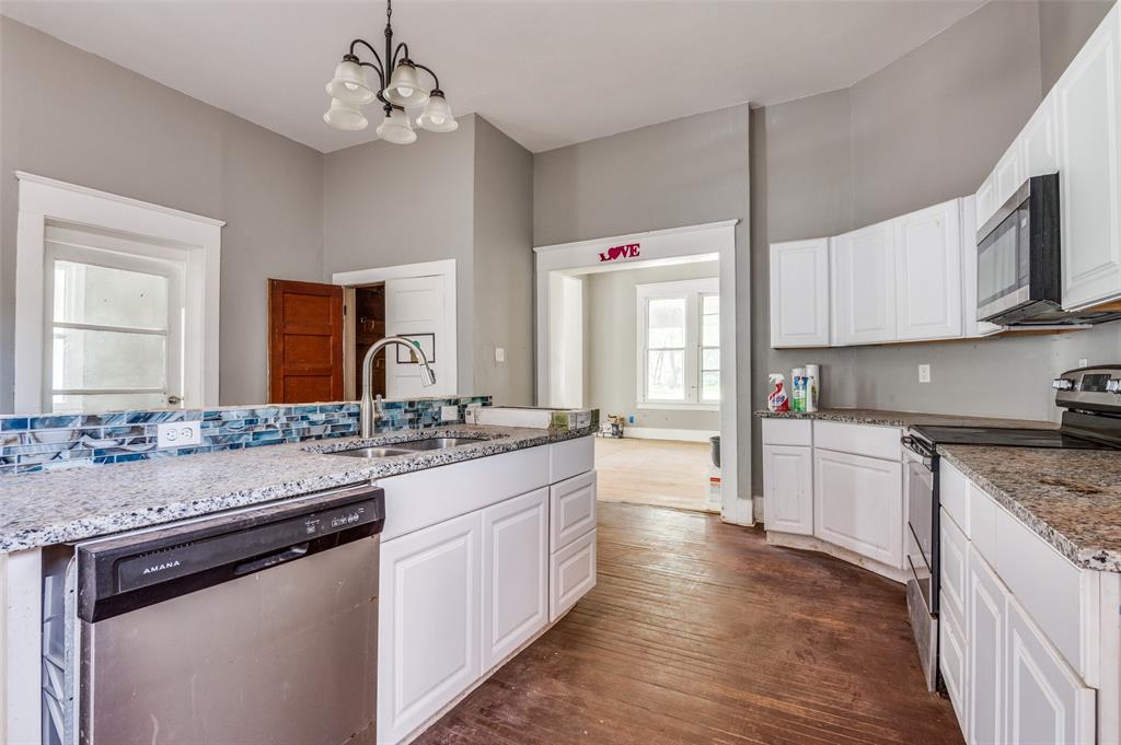 408 West Decatur Street Ennis, TX 75119 - Photo 7 of 15 a kitchen with stainless steel appliances granite countertop a sink stove and cabinets
