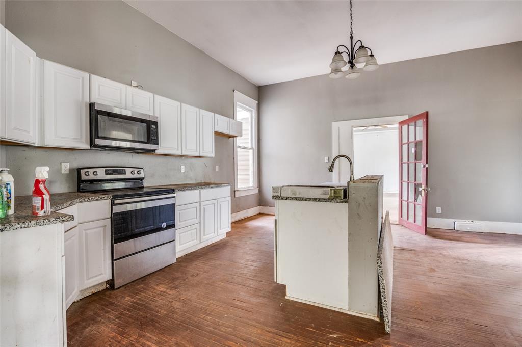 408 West Decatur Street Ennis, TX 75119 - Photo 8 of 15 a kitchen with stainless steel appliances granite countertop a stove top oven a sink and a refrigerator