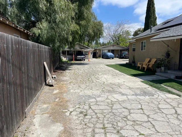 a view of a house with backyard and a trees