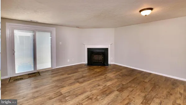 wooden floor fireplace and natural light in room