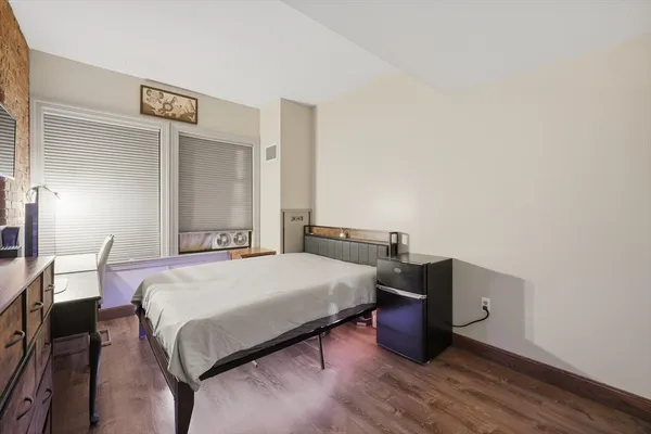 a bedroom with a bed and wooden floor