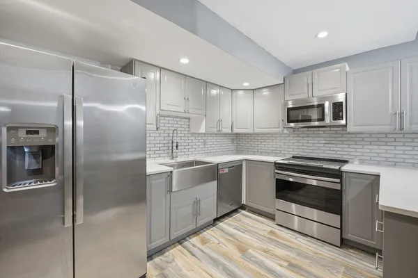 a kitchen with granite countertop a refrigerator stove and microwave
