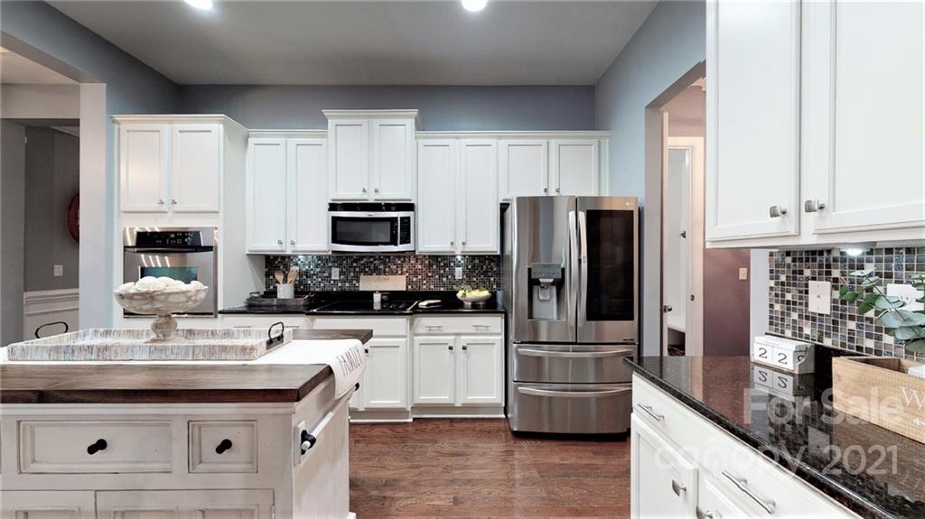 2007 Fallondale Road Waxhaw, NC 28173 - Photo 14 of 48 a kitchen with stainless steel appliances a sink a stove a microwave a sink and cabinets