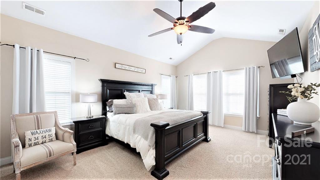 2007 Fallondale Road Waxhaw, NC 28173 - Photo 29 of 48 a bedroom with a bed a couch and a chandelier