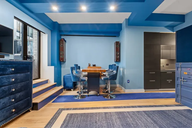a living room with furniture a desk and chair with wooden floor