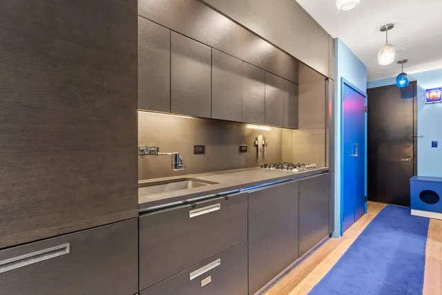 a kitchen with stainless steel appliances a refrigerator and a hard wood floor