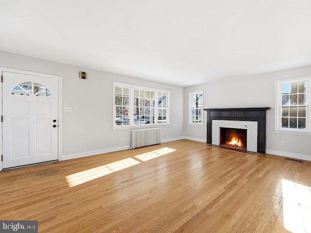 201 Grape Street Hammonton, NJ 08037 - Photo 7 of 34 an empty room with wooden floor fireplace and windows