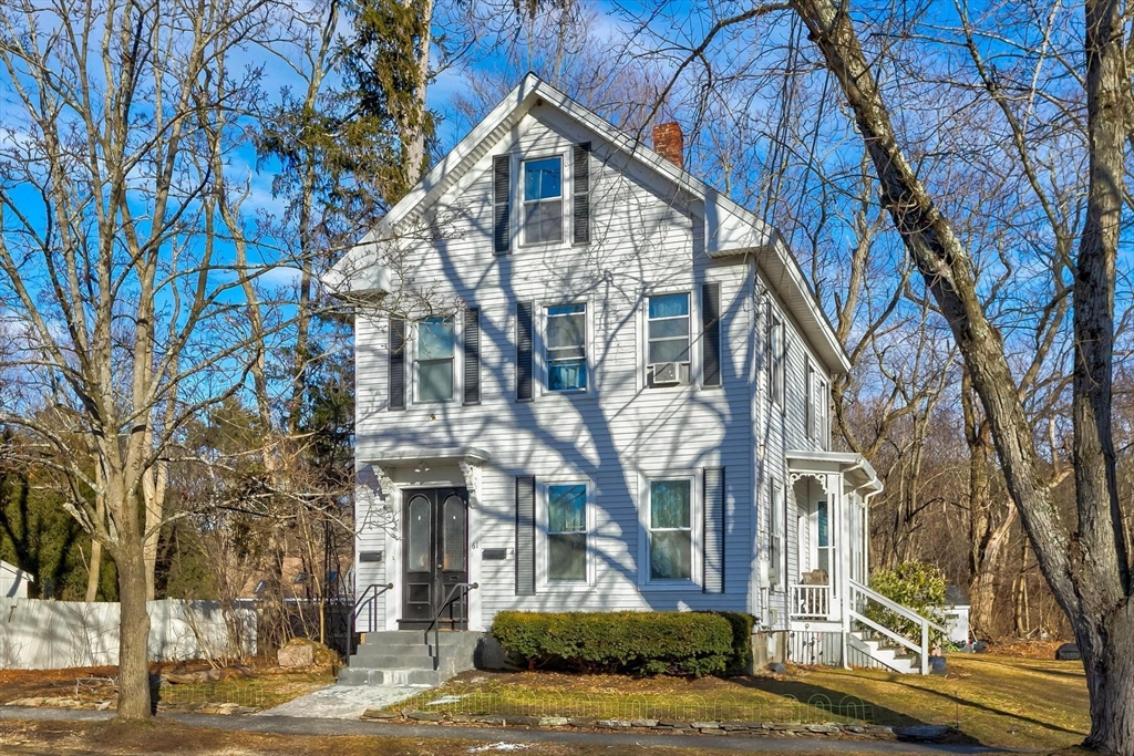 a view of a white house with a yard and potted plants