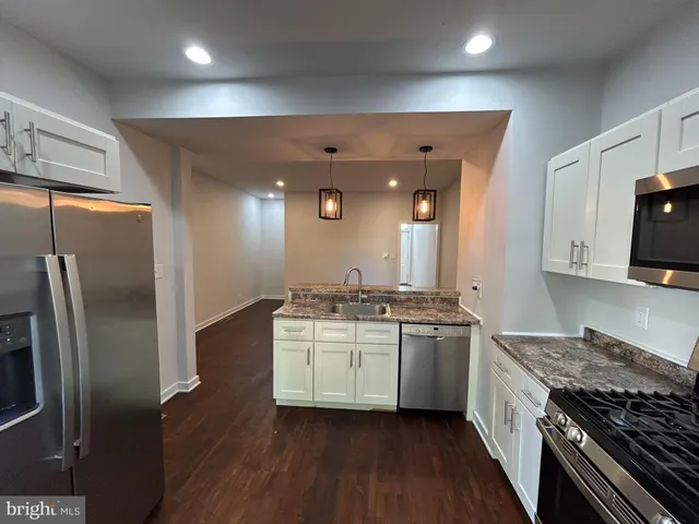 a kitchen with stainless steel appliances granite countertop a stove and a refrigerator