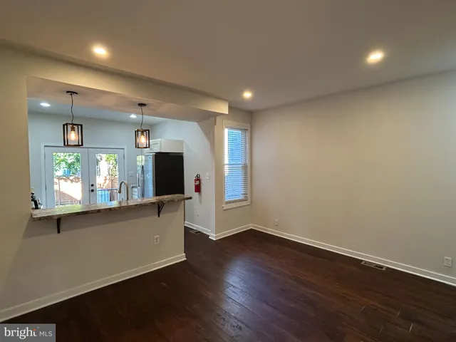 an empty room with wooden floor and window