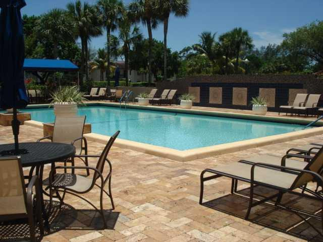 21218 Lago Circle, Unit B Boca Raton, FL 33433 - Photo 24 of 25 a view of a lake with table and chairs potted plants and large tree