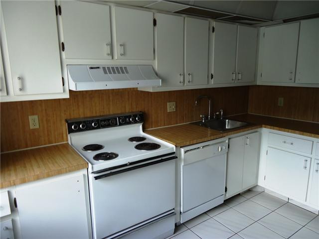 21218 Lago Circle, Unit B Boca Raton, FL 33433 - Photo 8 of 25 a kitchen with granite countertop white cabinets and white appliances