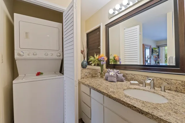 a bathroom with a granite countertop sink and a mirror