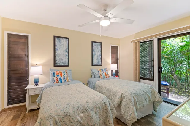 a bedroom with two beds and a large window