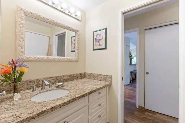 a bathroom with a granite countertop sink and a mirror