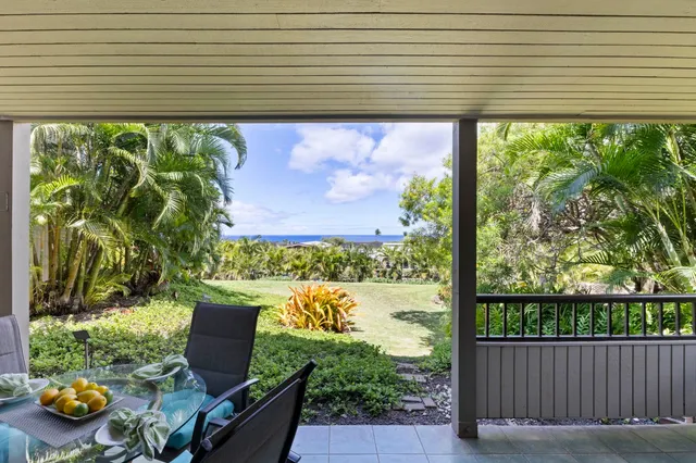 a view of a chairs and table in the back yard of a house