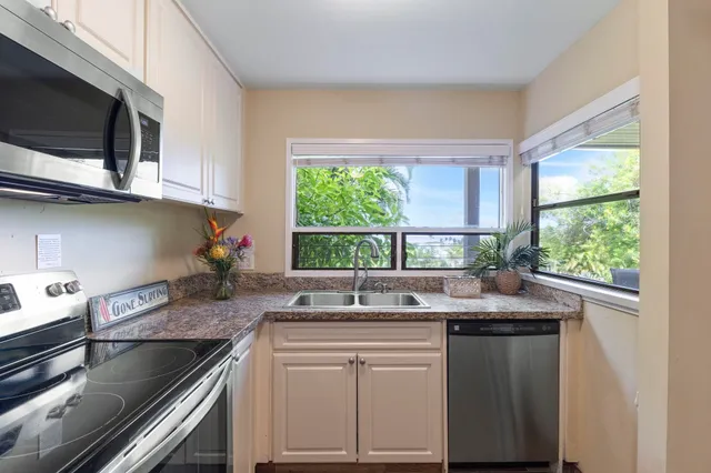 a kitchen with granite countertop a sink and a stove top oven