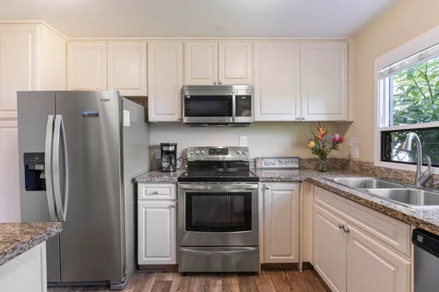 a kitchen with cabinets stainless steel appliances and a sink