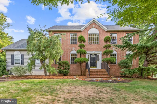 a front view of a house with a garden and plants