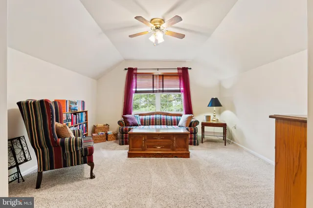 a bedroom with a bed a computer on a desk and chair