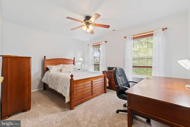 a bathroom with a toilet a sink a mirror and a window