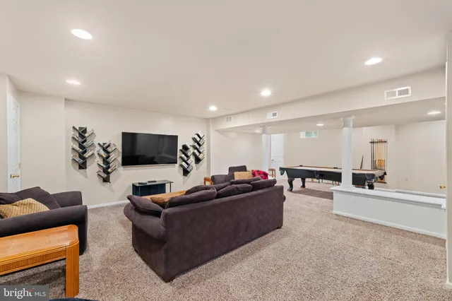 a room with furniture a air conditioner vent and a window