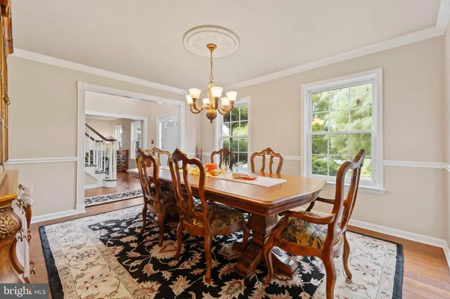 a dining room with furniture a chandelier and wooden floor