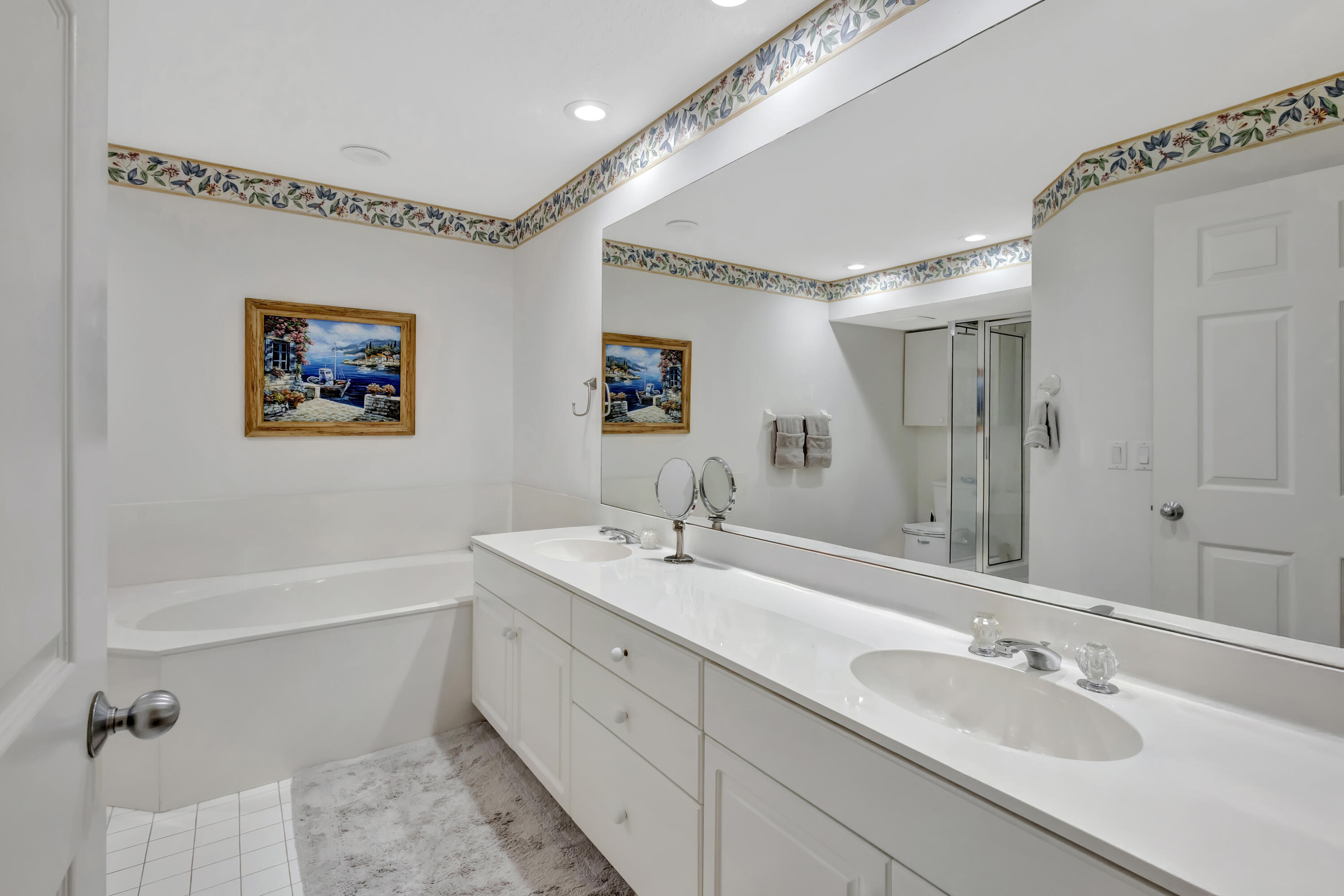 411 Northeast Plantation Road, Unit 522 Stuart, FL 34996 - Photo 22 of 52 a bathroom with 2 sink tub and a mirror