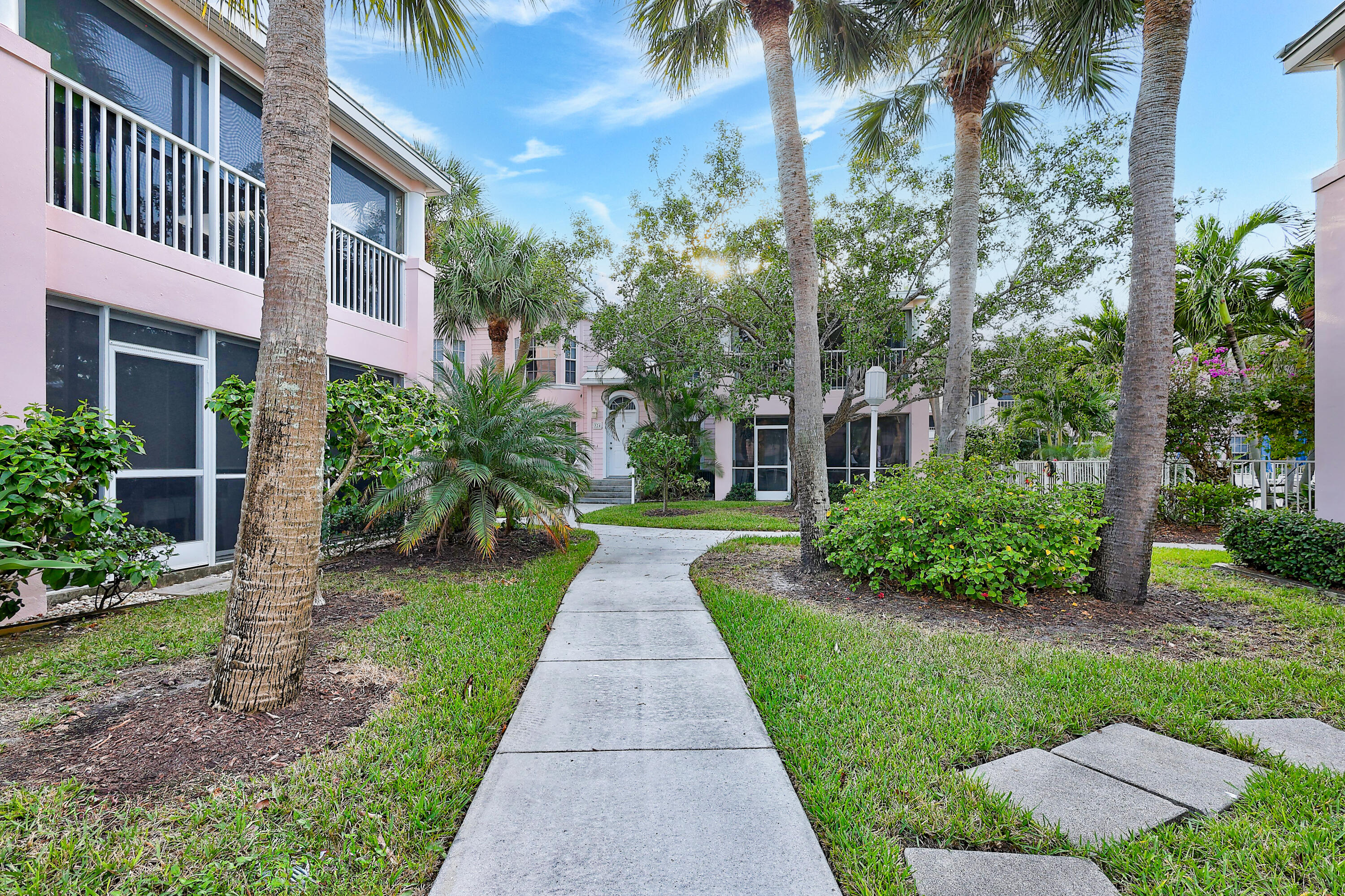 411 Northeast Plantation Road, Unit 522 Stuart, FL 34996 - Photo 27 of 52 a front view of a house with a yard and potted plants