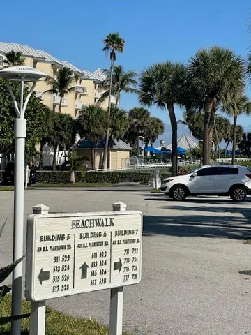 a view of a street with a building and palm trees