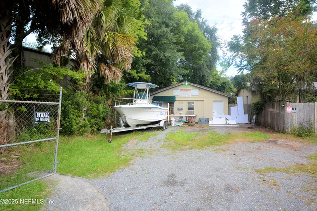 a view of a backyard with table and chairs and a large tree