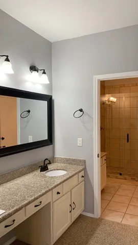 a bathroom with a granite countertop sink mirror and shower