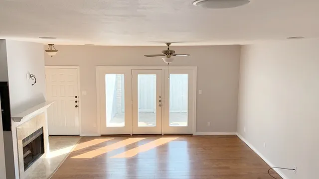 a view of an empty room with a fireplace and a window