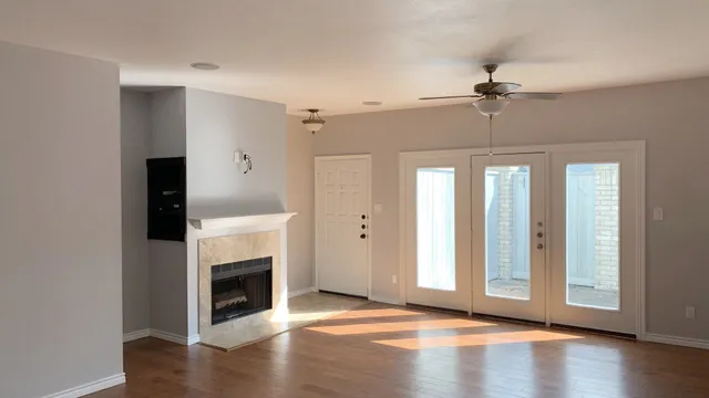 a view of a livingroom with a fireplace wooden floor and windows