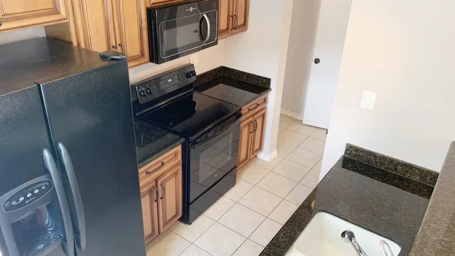 a kitchen with stainless steel appliances granite countertop a refrigerator and a stove