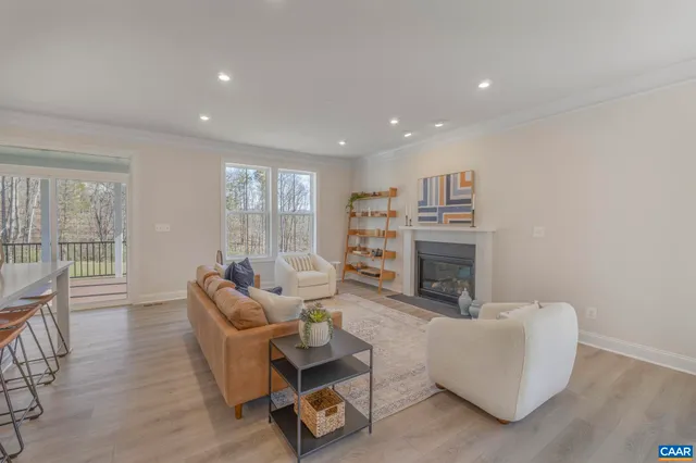 a living room with furniture a fireplace and a large window