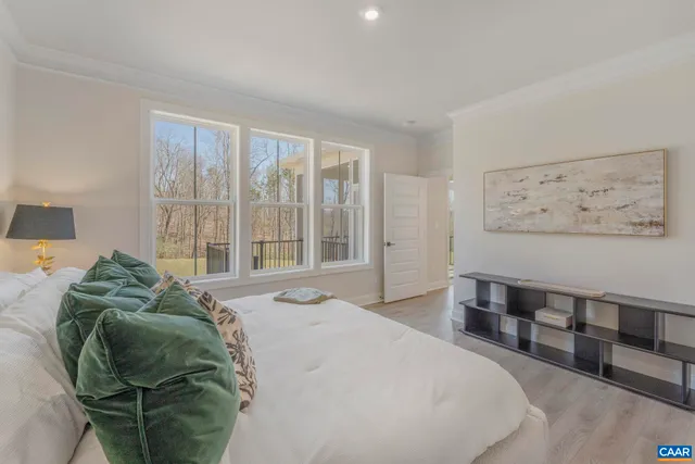 a bed sitting in a bedroom next to a window